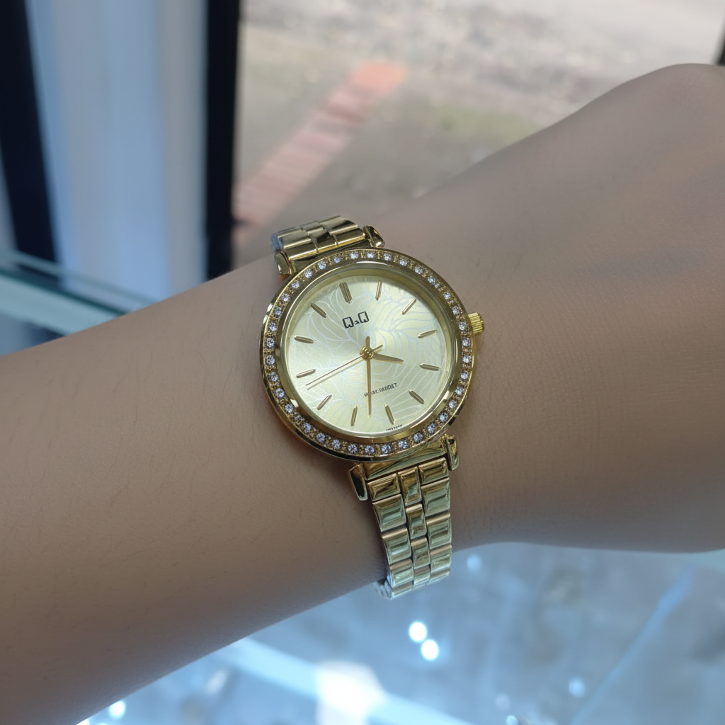 Reloj Q&Q champagne dorado en muñeca femenina