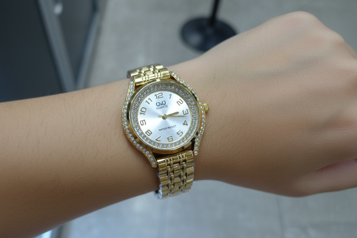 Reloj Q&Q dorado en muñeca femenina