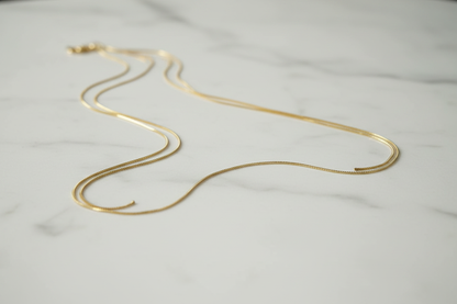 Cadena lisa oro 18k sobre mármol blanco