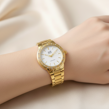 Reloj Q&Q dorado con cristales en muñeca femenina